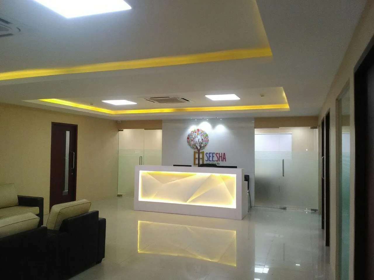 Backlit Geometric Feature Desk with Cove Lighting and Minimalist Interior with Reception Desks at Deskanddecor